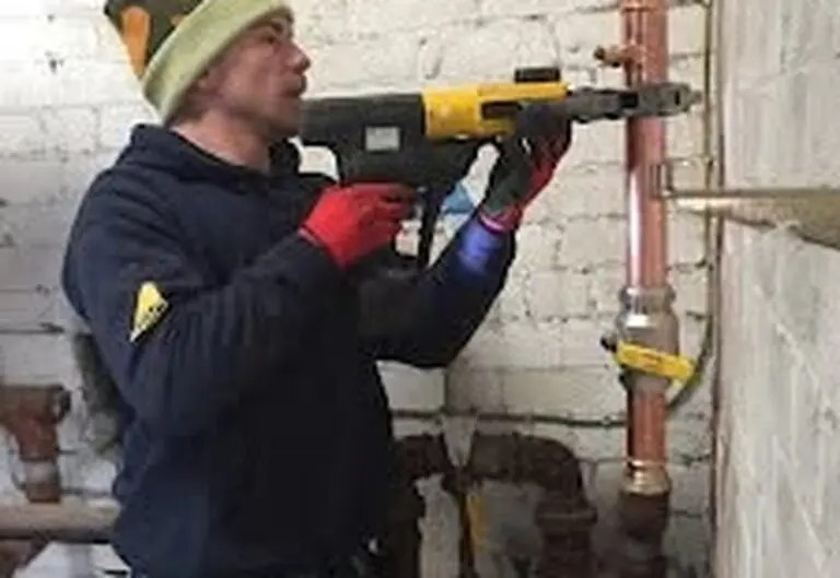 Heat365 engineer core-drilling for pipework in a Sheffield property