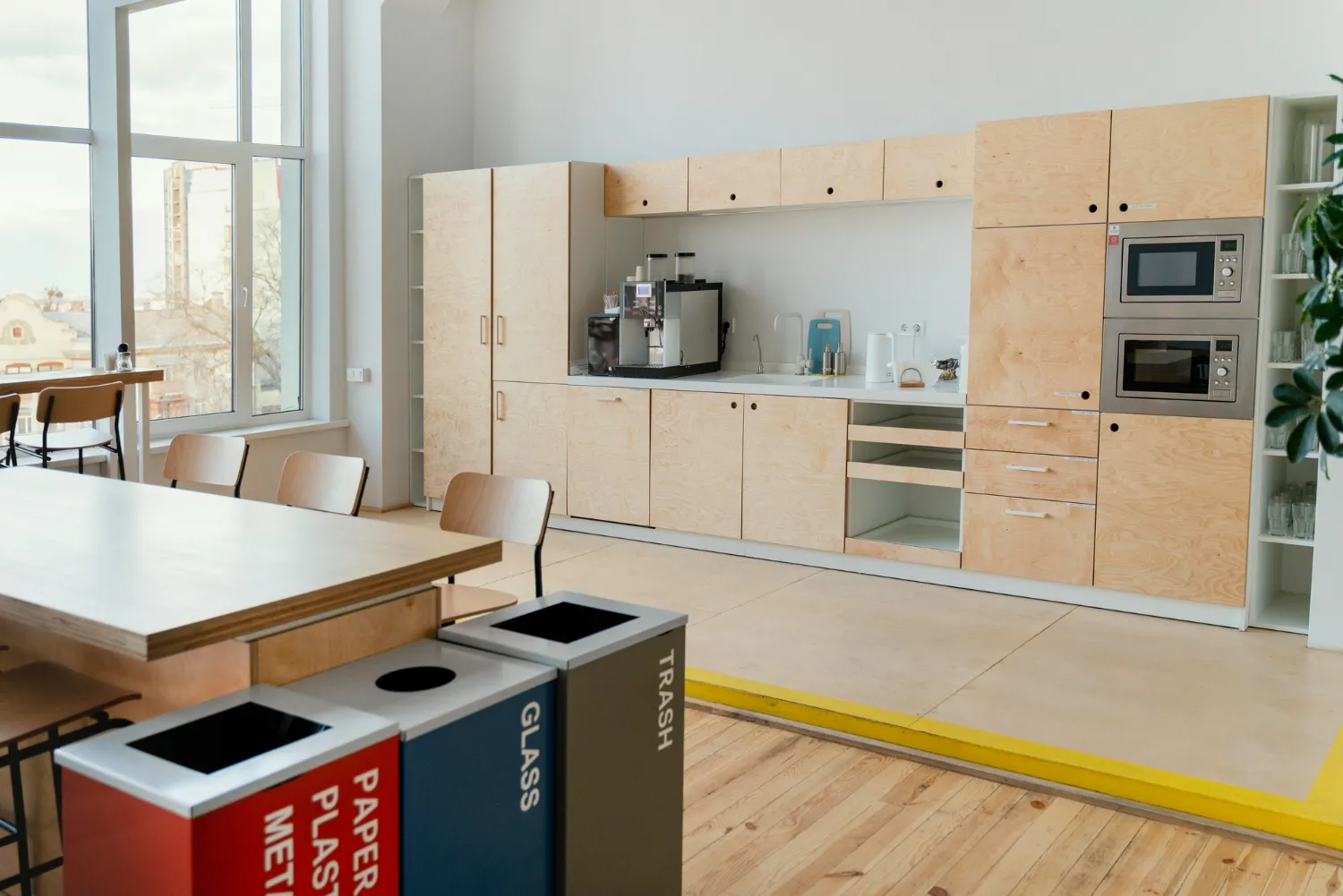 a room with a table and chairs and a table with trash cans